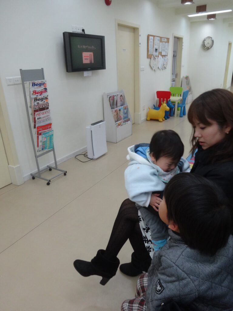 上海ファミリークリニックの待合室で診察を待つ家族