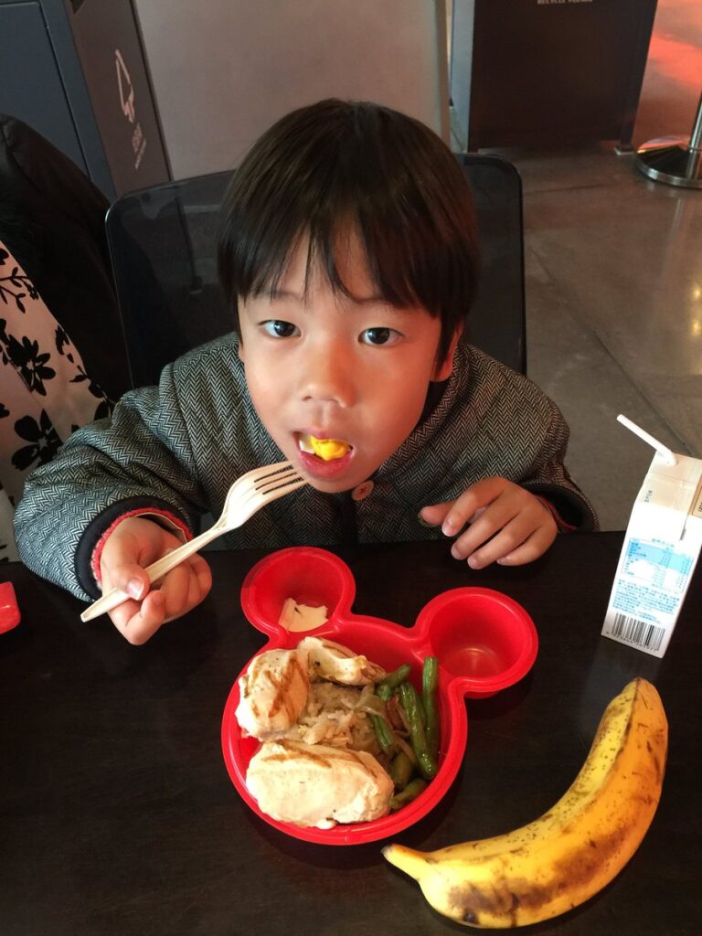 上海ディズニーランドで食事をする子ども