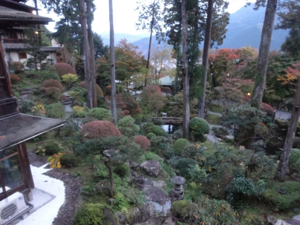 湯之島館の客室から眺める紅葉した日本庭園