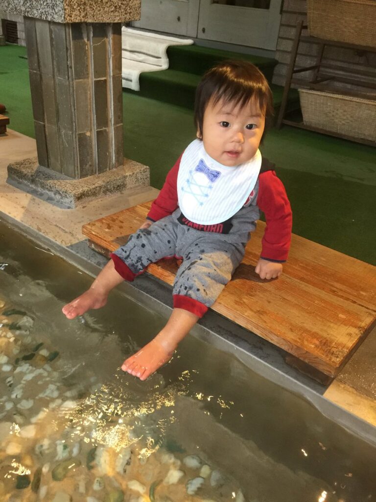 湯之島館の館内にある足湯を楽しむ子供