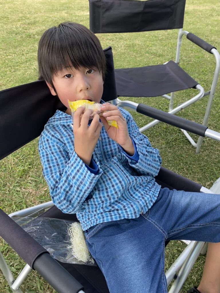 荒川運動公園でBBQを楽しみながら食事をする子供