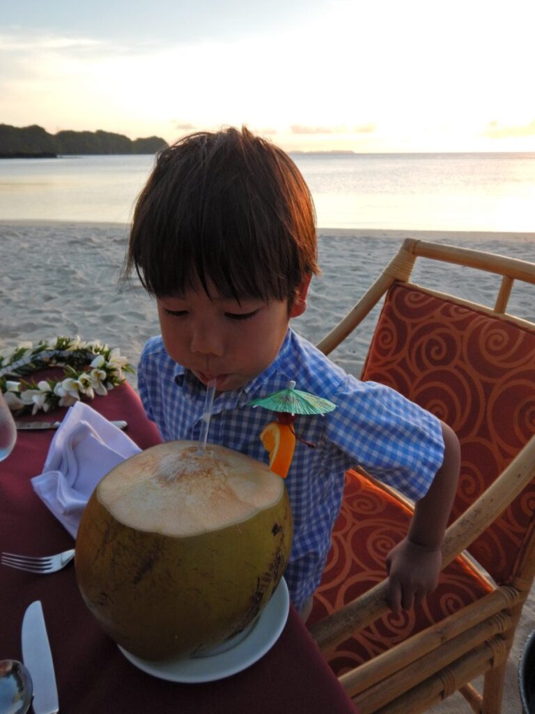 パラオのビーチディナーでココナッツドリンクを楽しむ子供