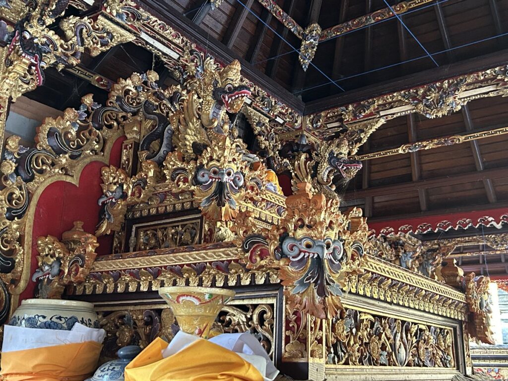 ティルタ・エンプル寺院の祠に施された金色の彫刻と供物